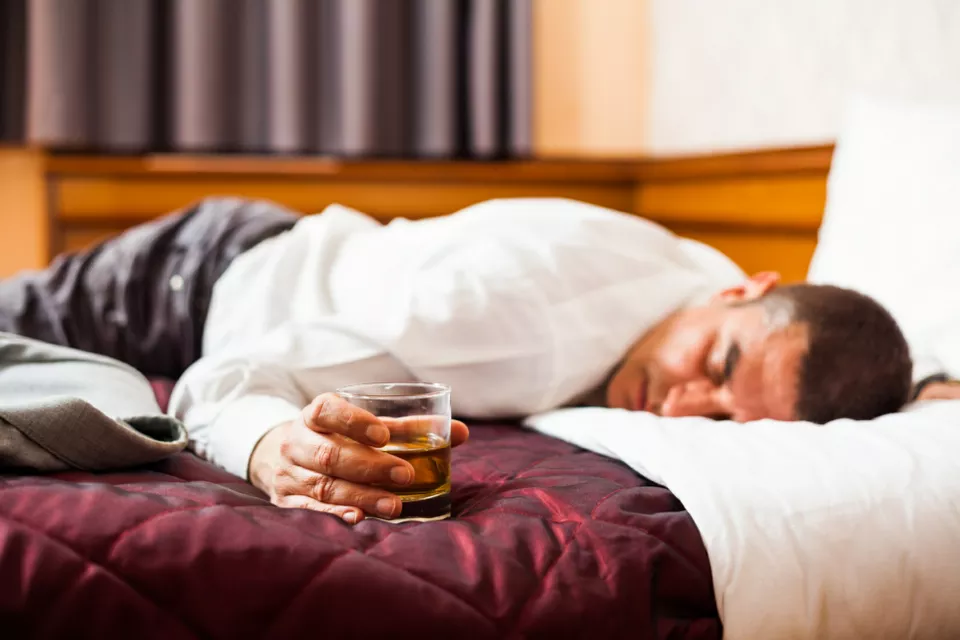 alcohol abuse man unsconscious on hotel bed