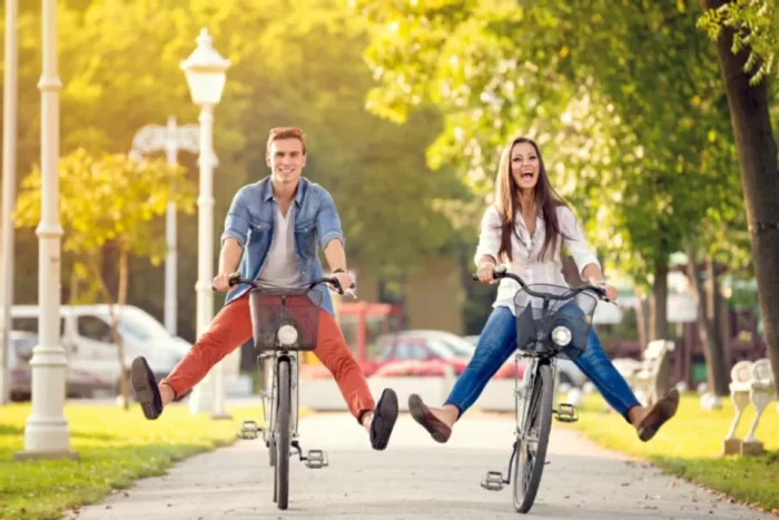 Happy young couple riding their bikes in the autumn light