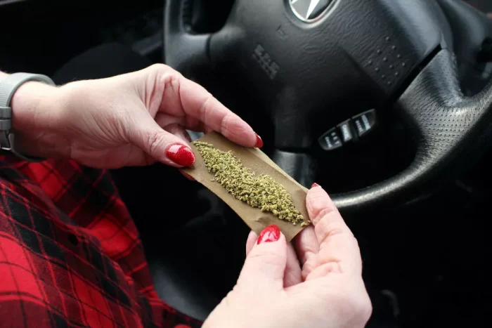 Woman rolling a joint in her car