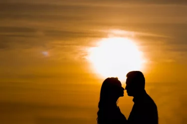 Lovers standing against a sunset