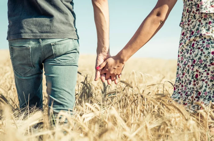 Relationship counselling in Wolverhampton couple holding hands walking in barley field